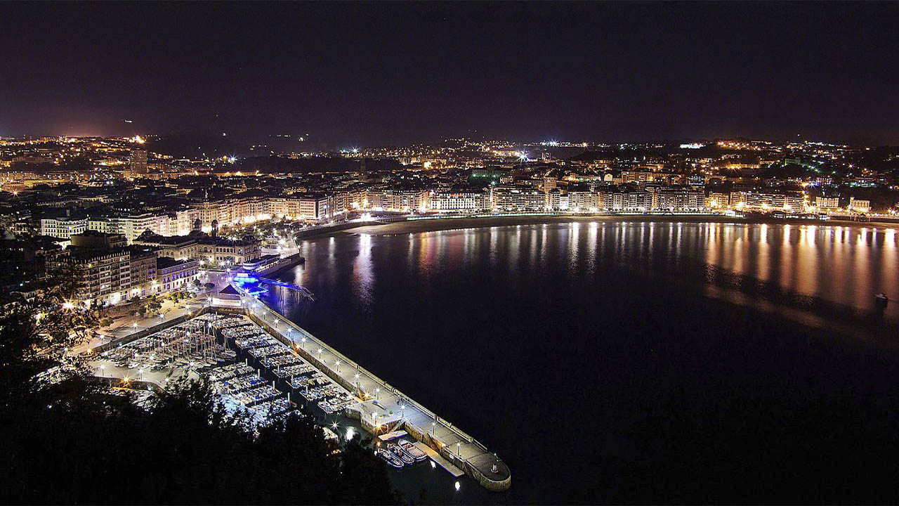 Vista nocturna de San Sebastian desde el Monte Urgull by Wikimdia Commons
